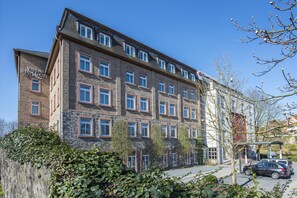 Un immeuble à plusieurs étages, doté d’une façade en briques, de nombreuses fenêtres et d’une enseigne indiquant qu’il s’agit d’un hôtel.