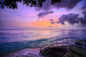 A coastal scene with a staircase leading to a white railing overlooking the ocean. - The Club, Barbados Resort & Spa Adults Only - All Inclusive (Holetown)