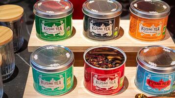 Une sélection de boîtes de thé KUSMI TEA, présentées sur une étagère en bois.