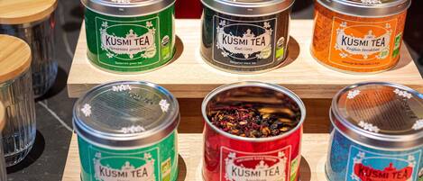 Une sélection de boîtes de thé KUSMI TEA, présentées sur une étagère en bois.