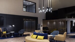 A modern lounge area with a curved sofa, armchairs, and a small table.