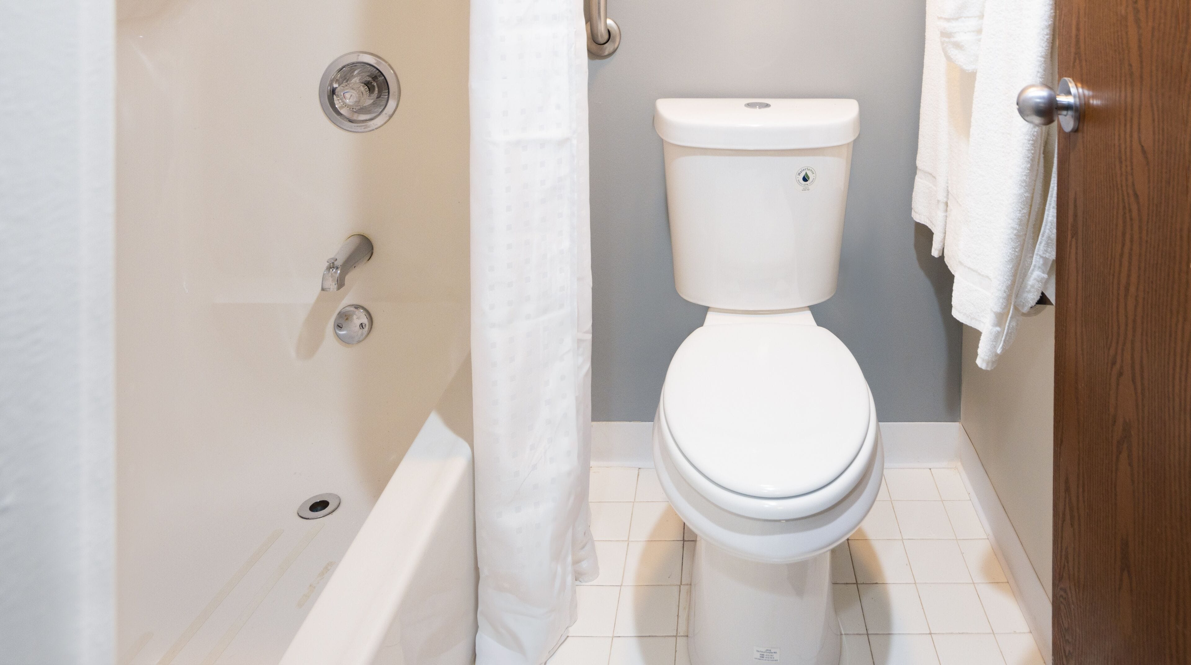 Un baño con inodoro, bañera y cortina de ducha.