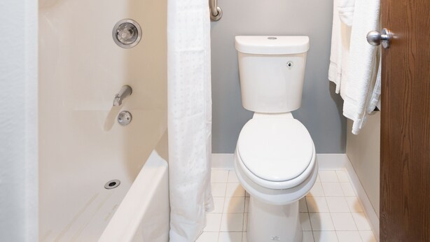 Un baño con inodoro, bañera y cortina de ducha.