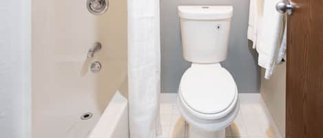 Un baño con inodoro, bañera y cortina de ducha.
