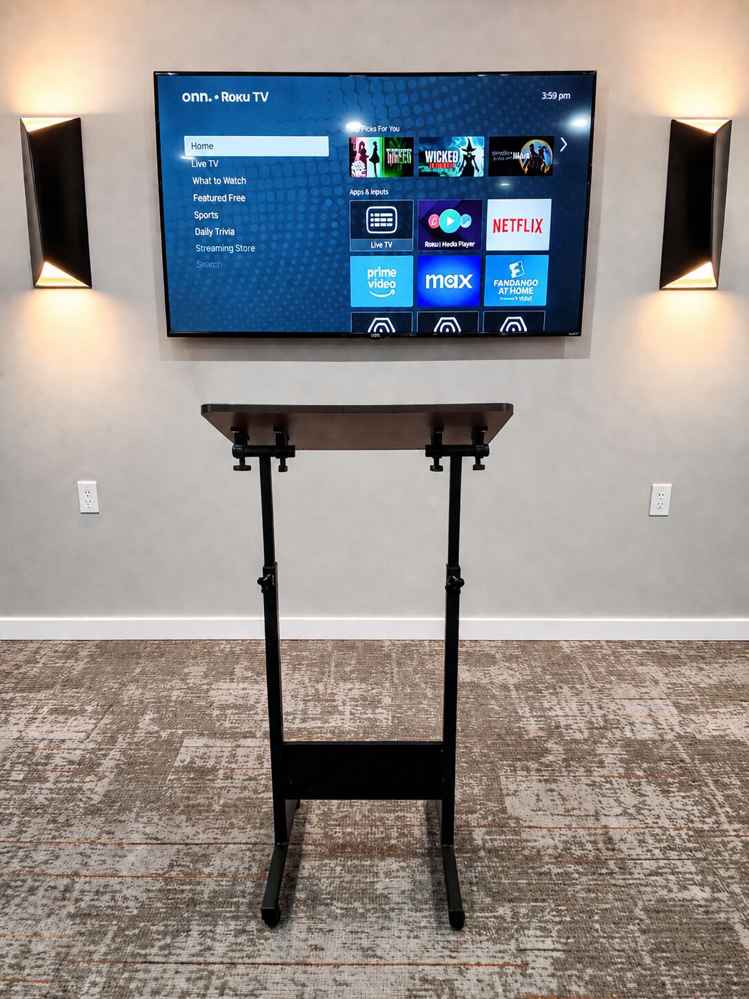 Un téléviseur à écran plat fixé au mur, avec une table placée devant.