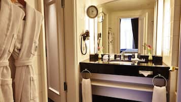 Et badeværelse på et hotel med en sort vask, hvide håndklæder og et spejl.