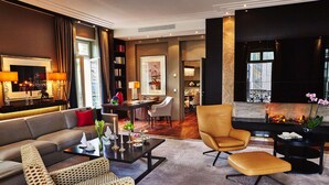 Ein modernes Wohnzimmer mit einer Couch, Sesseln, einem Couchtisch und einem Kamin.