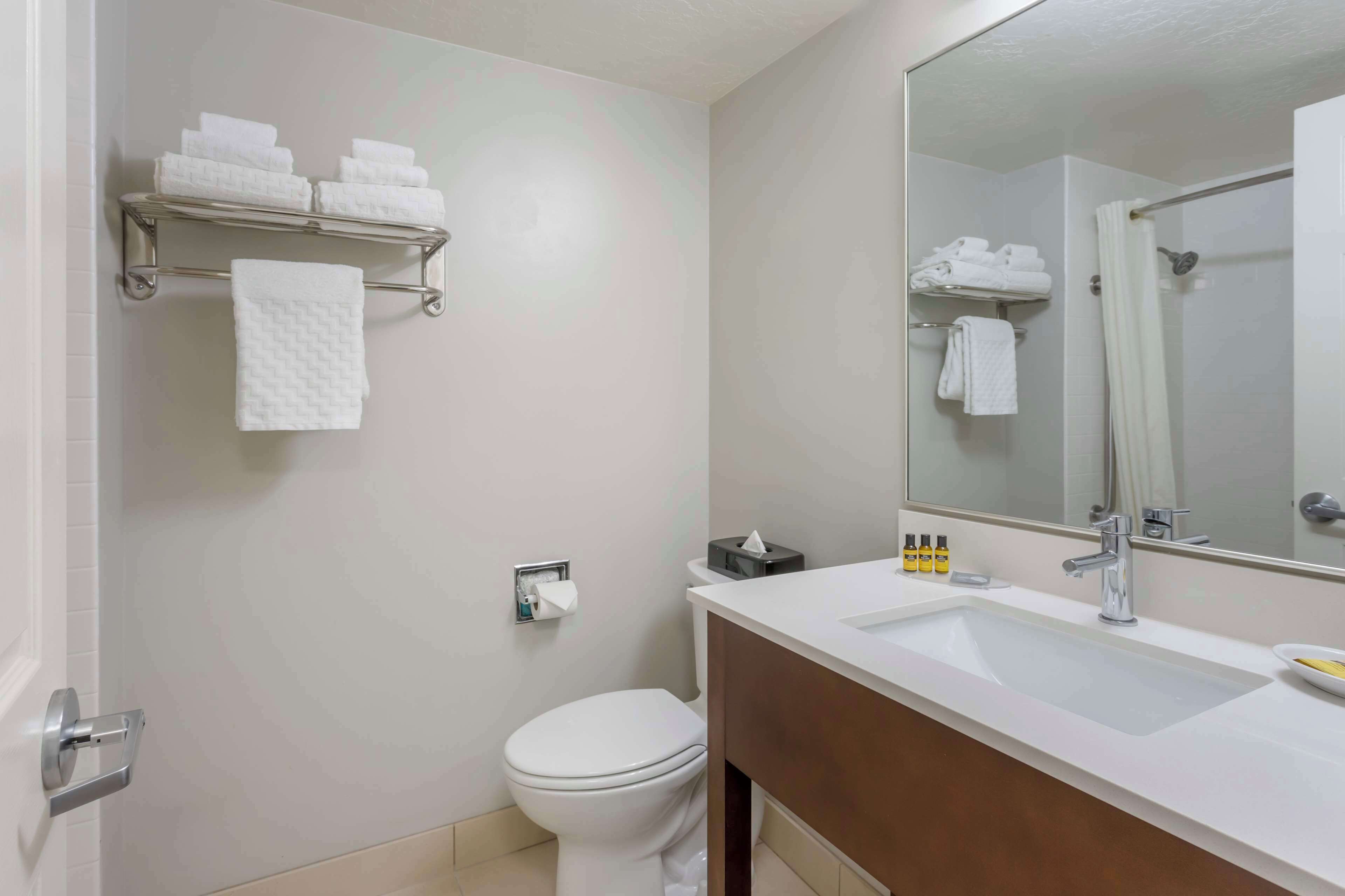 Une salle de bain équipée de toilettes, d’un lavabo et d’un porte-serviettes.