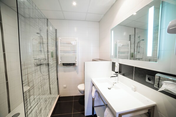 A modern bathroom with a glass shower enclosure, a white sink, and a large mirror. - Hôtel Darcy Dijon Centre (Dijon)