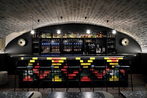 A bar with a brick ceiling, a colorful bar counter, and black bar stools. - Hôtel Darcy Dijon Centre (Dijon)