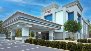 A modern hotel with a prominent entrance, covered parking, and a clear sky. - Hampton Inn Memphis-Poplar (Memphis)