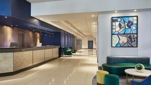 A modern hotel lobby with a reception desk, seating area, and artwork on the wall. - Cardiff Marriott Hotel (Cardiff)