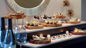 A buffet with various food items and a wine bottle. - Gaithersburg Marriott Washingtonian Center (Gaithersburg)