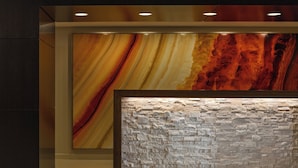 A reception area with a stone-textured wall and a large abstract painting. - Gaithersburg Marriott Washingtonian Center (Gaithersburg)