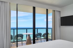 A hotel room with a balcony, a bed, and a view of the ocean. - OUTRIGGER Waikiki Beach Resort (Honolulu)