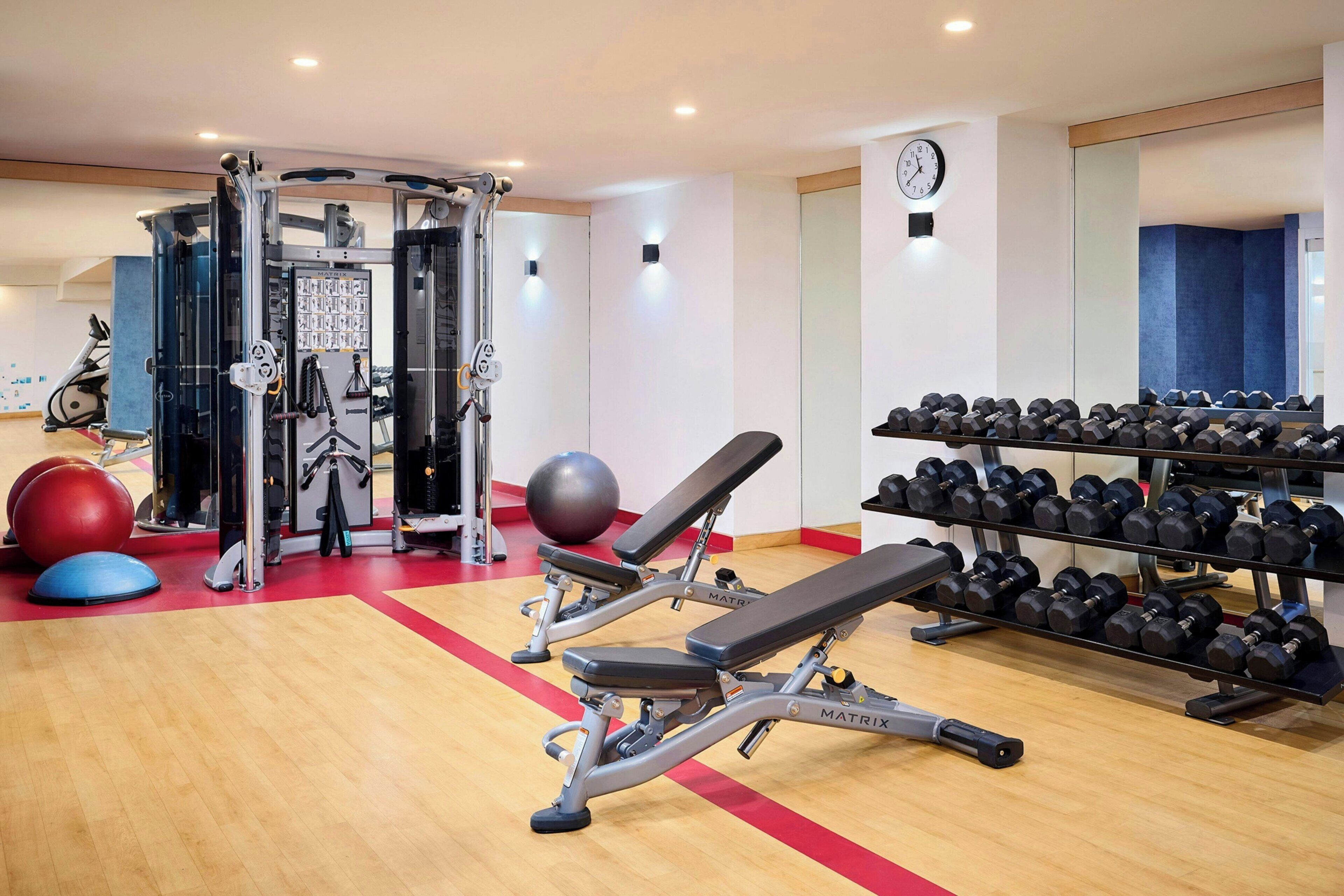 Une salle de sport équipée de matériel d’exercice, d’un banc et d’un porte-haltères.