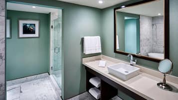 Une salle de bain moderne avec un grand miroir, deux vasques et une douche à l’italienne.