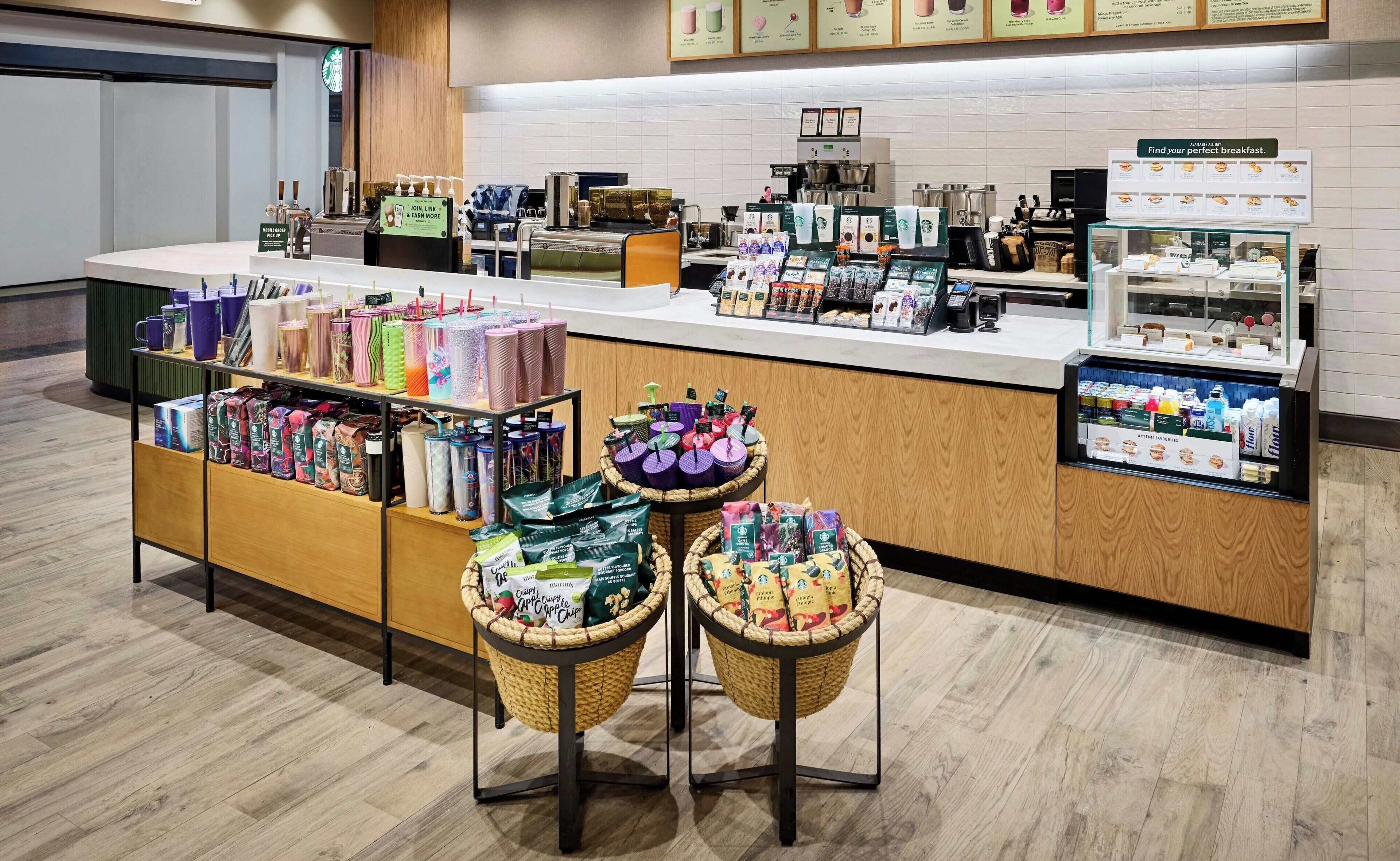 Starbucks-kahvila, jonka tiskillä ja koreissa on esillä monipuolinen valikoima juomia ja ruokatuotteita.
