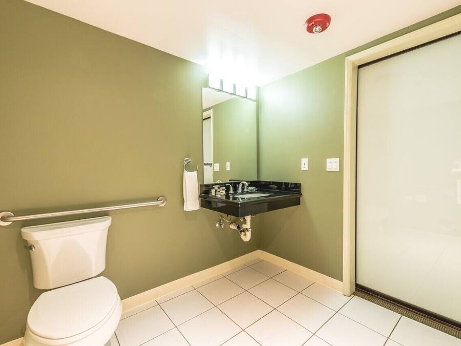 A bathroom with a toilet, a sink, and a glass shower enclosure.