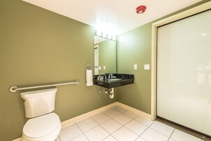 A bathroom with a toilet, a sink, and a glass shower enclosure.