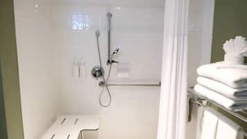 A bathroom with a shower, a bench, and a towel rack.