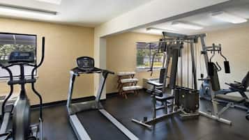 A gym with treadmills, weight machines, and benches.