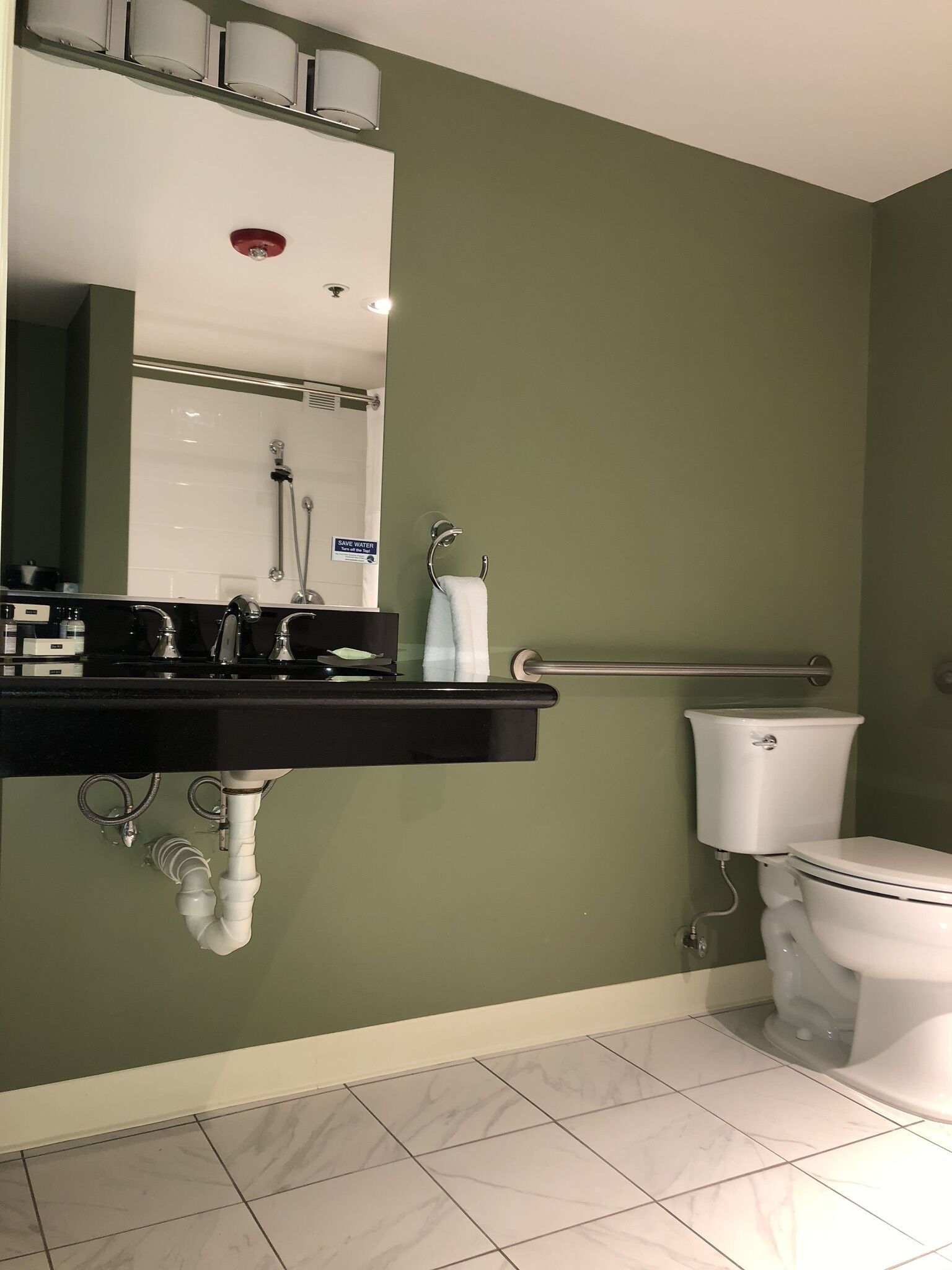 A bathroom with a black sink, a toilet, and a shower.