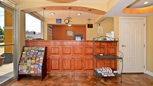 A reception area with a wooden reception desk, a clock, and a bulletin board with pamphlets.