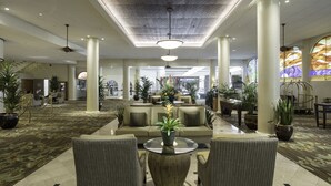 A spacious lobby with a high ceiling, large columns, and comfortable seating areas. - Waikiki Resort Hotel (Honolulu)