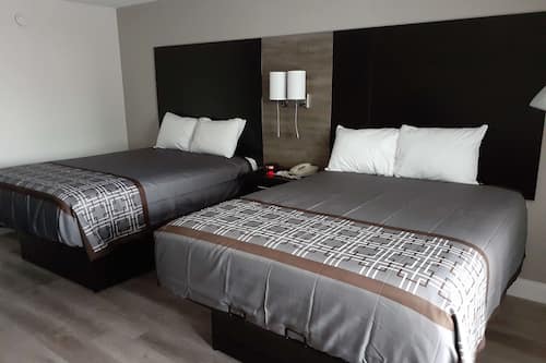 Habitación estándar, 2 camas Queen size | Tabla de planchar con plancha, wifi gratis y ropa de cama