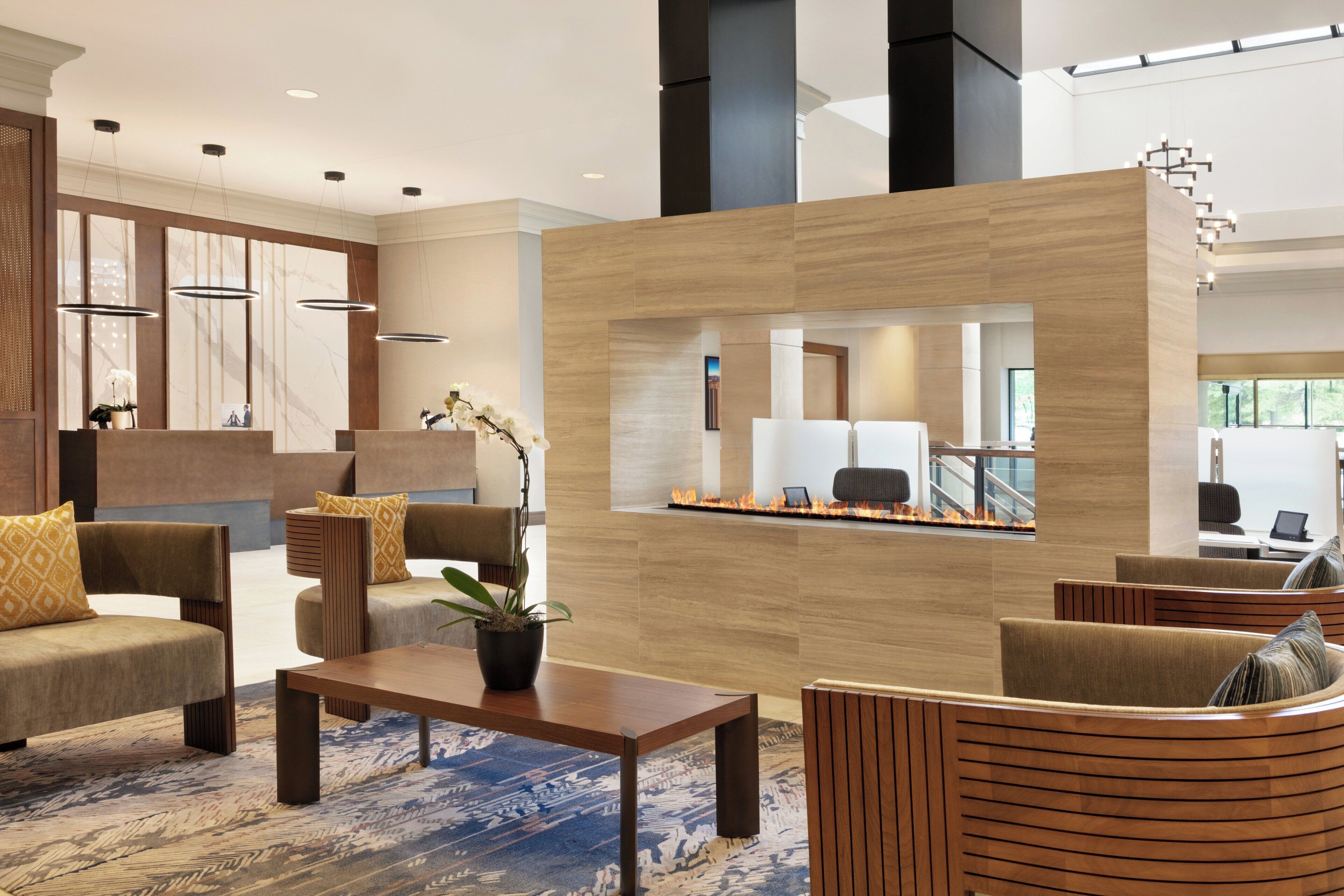 A modern lobby with seating areas, a reception desk, and a view of the interior.