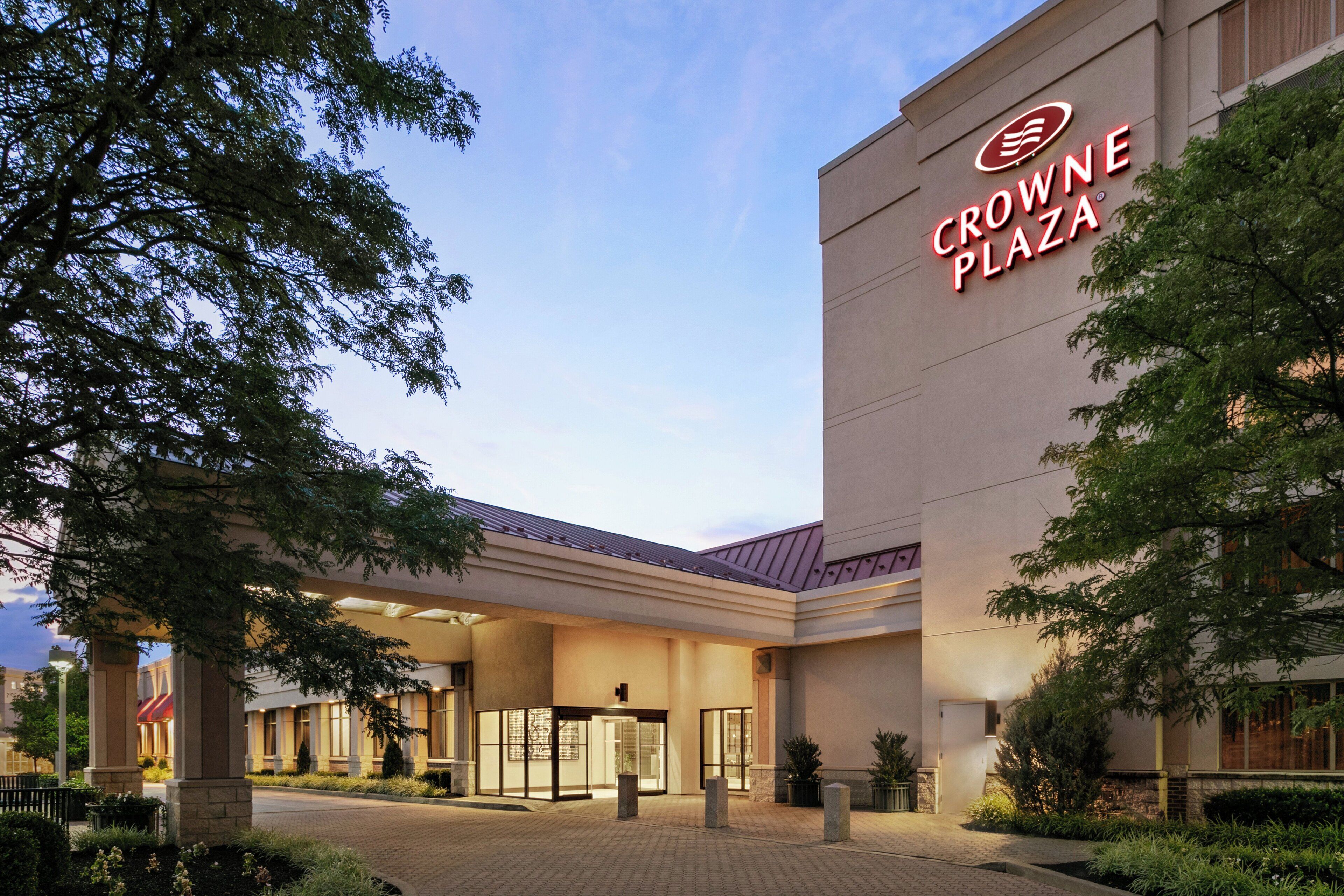 L’entrée d’un hôtel, avec une enseigne bien visible indiquant « CROWNE PLAZA ».