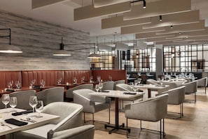 A modern restaurant interior with booths, tables, and hanging pendant lights. - Crowne Plaza: Philadelphia - King of Prussia by IHG (King of Prussia)