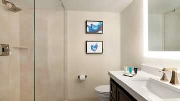 Une salle de bain moderne avec une douche à parois de verre, des toilettes et un meuble-lavabo avec un miroir.