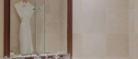 A bathroom with a large mirror, a sink, and a bathtub.