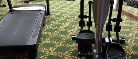 A gym with exercise equipment, a treadmill, and a stationary bike.