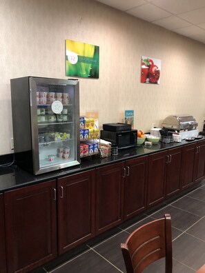 A breakfast bar with a refrigerator, hot and healthy food options, and a toaster.