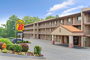 A motel with a sign reading "Super 8" and a sign stating "All rooms micro fridge new TVs."
