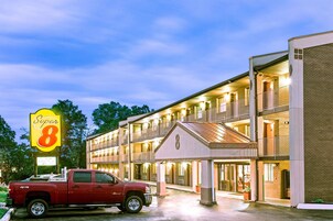 A motel with a sign reading "Super 8" and a red pickup truck parked in front.