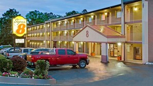 A motel with a prominent 'Super 8' sign, multiple balconies, and a parking lot with several vehicles. - Super 8 by Wyndham Laurel (Laurel)