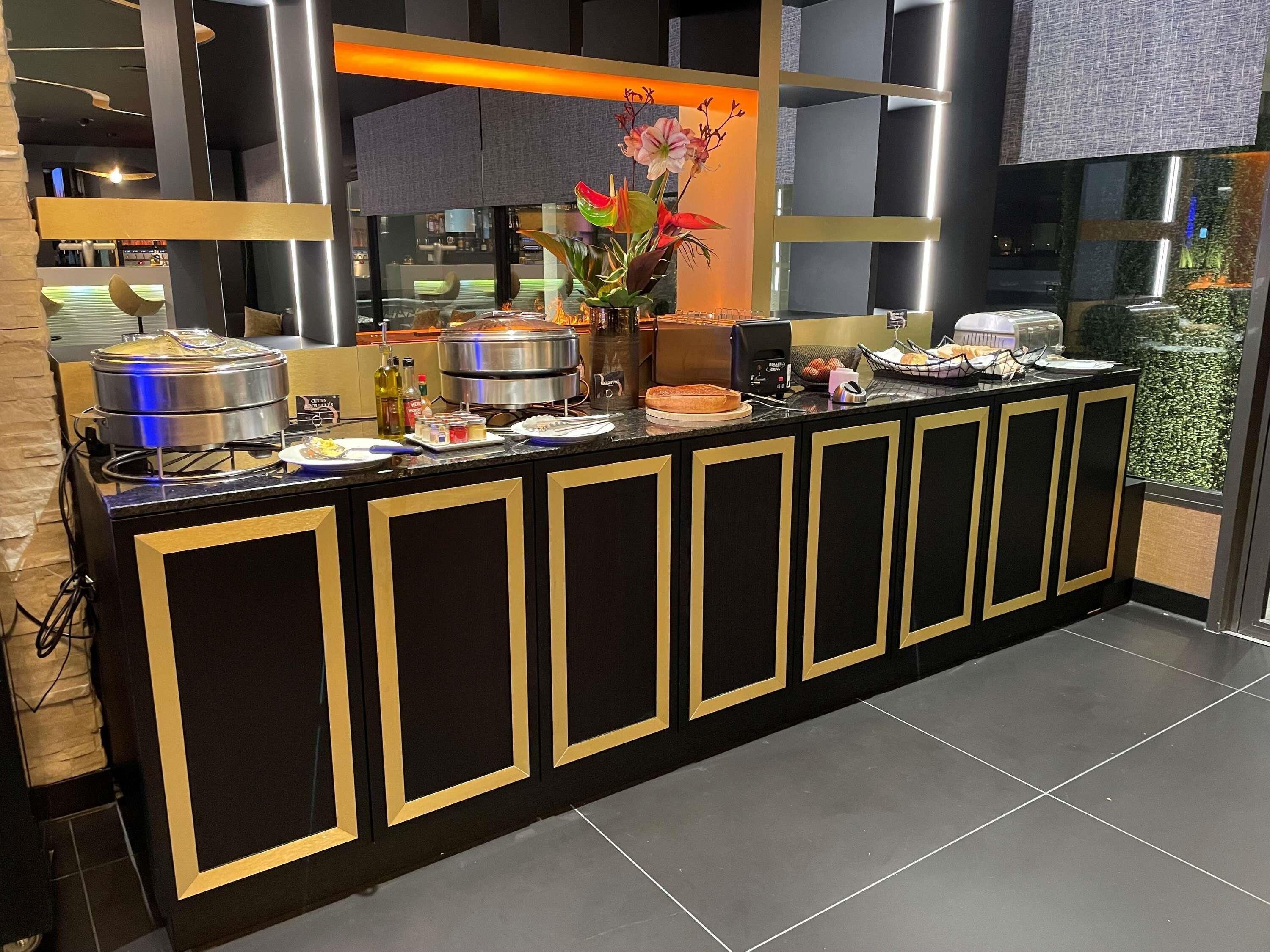 Un buffet proposant une grande variété de plats, un grand arrangement floral et un design moderne agrémenté de touches noires et dorées.