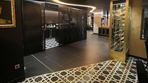 Un interior moderno con una lámpara de techo curva, piso estampado y una estantería para vinos.