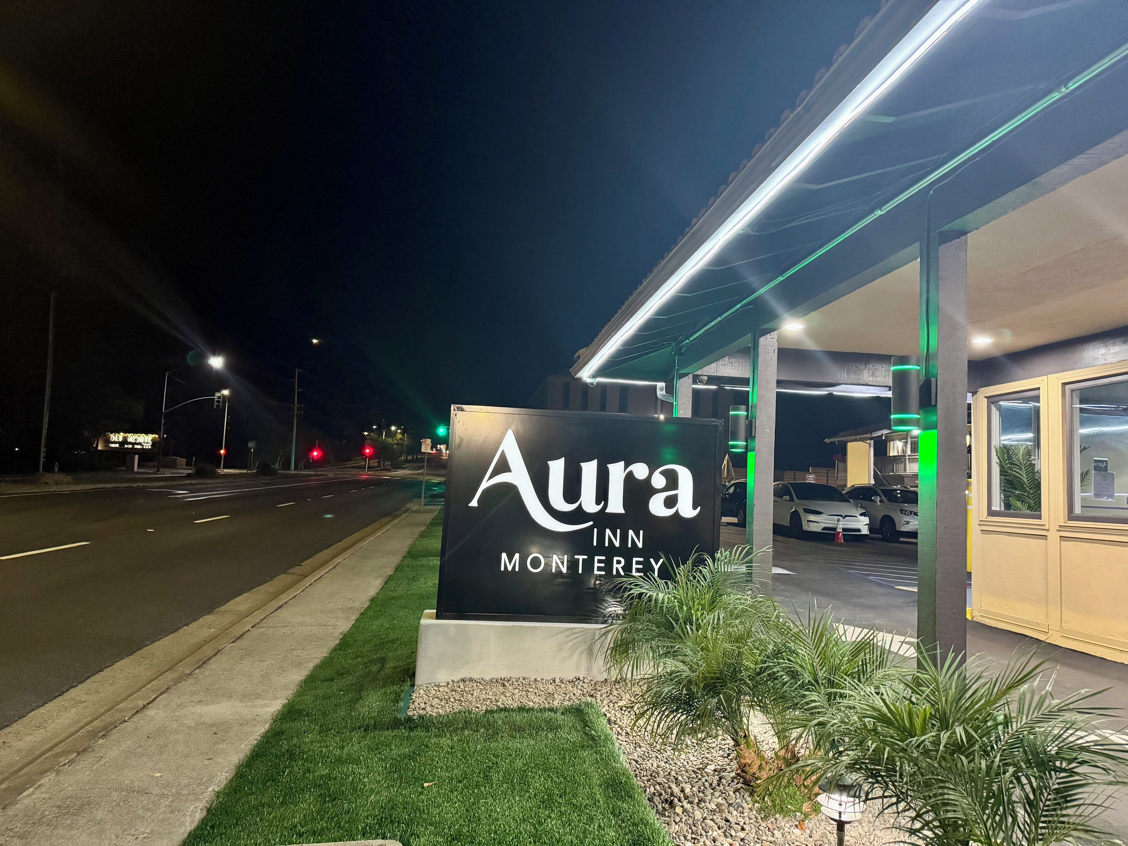 L’entrée d’un hôtel, avec une enseigne indiquant : « Aura Inn Monterey ».