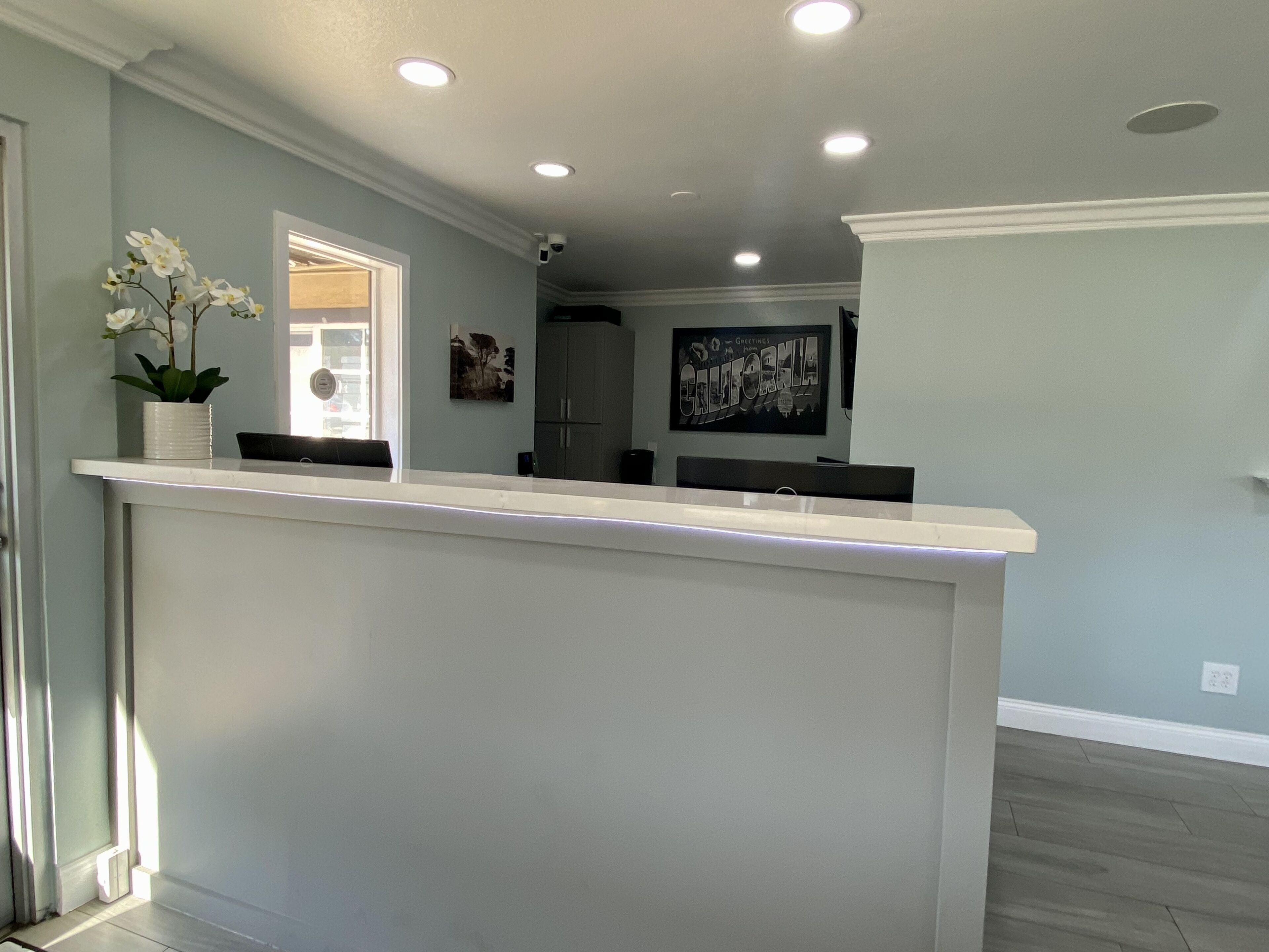 A modern kitchen with a central island, recessed lighting, and a view of the living area.