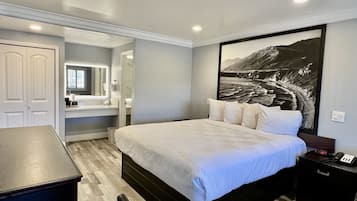 A bedroom with a bed, bedside table, and a large framed picture on the wall.
