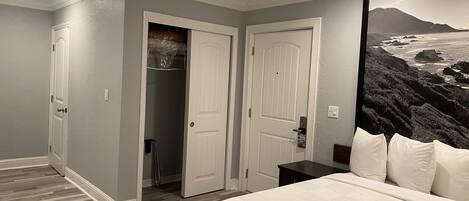 A bedroom with a bed, a closet, and a door leading to a bathroom.