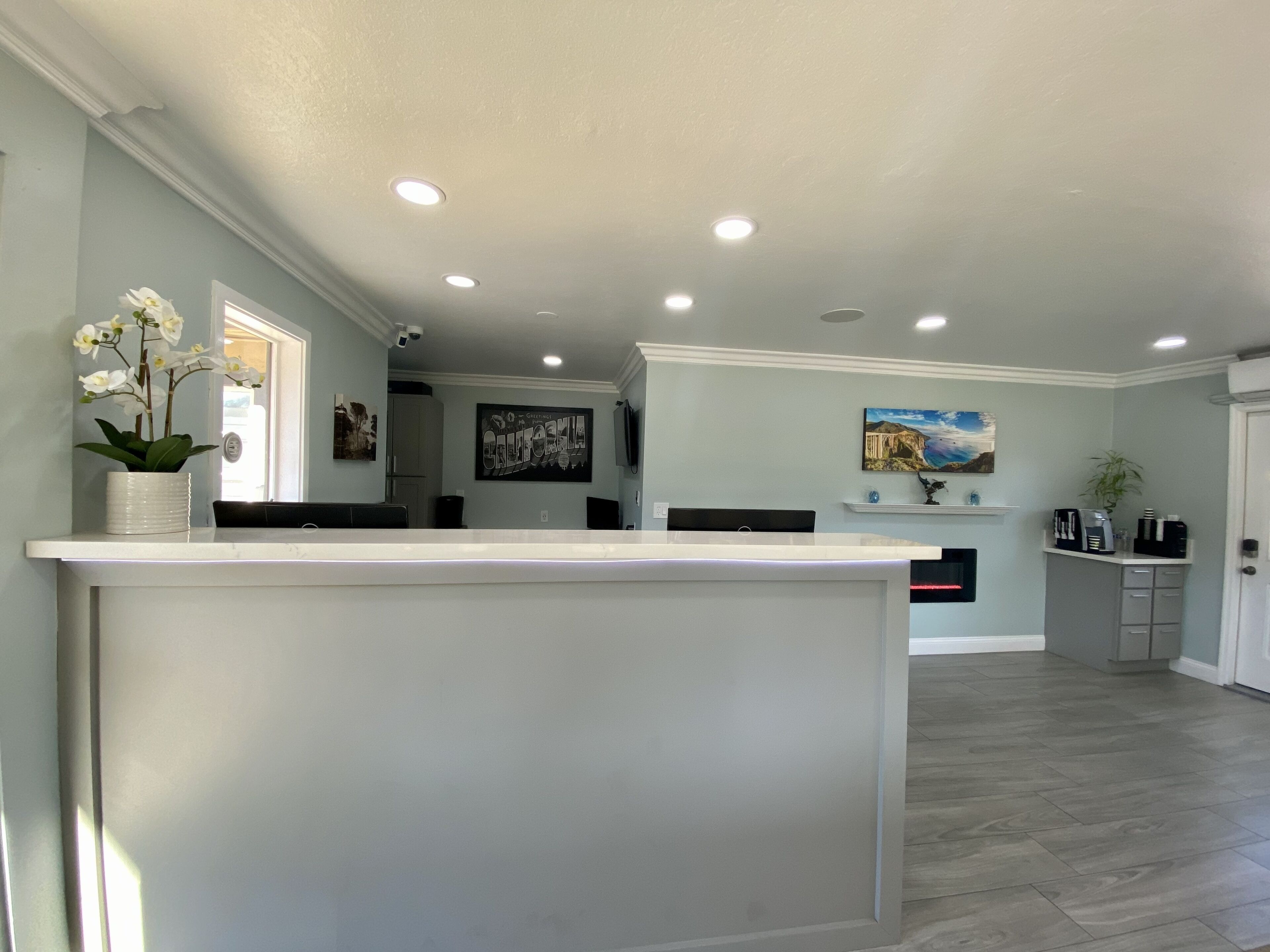 A spacious kitchen with a central island, recessed ceiling lights, and a view into the dining area.