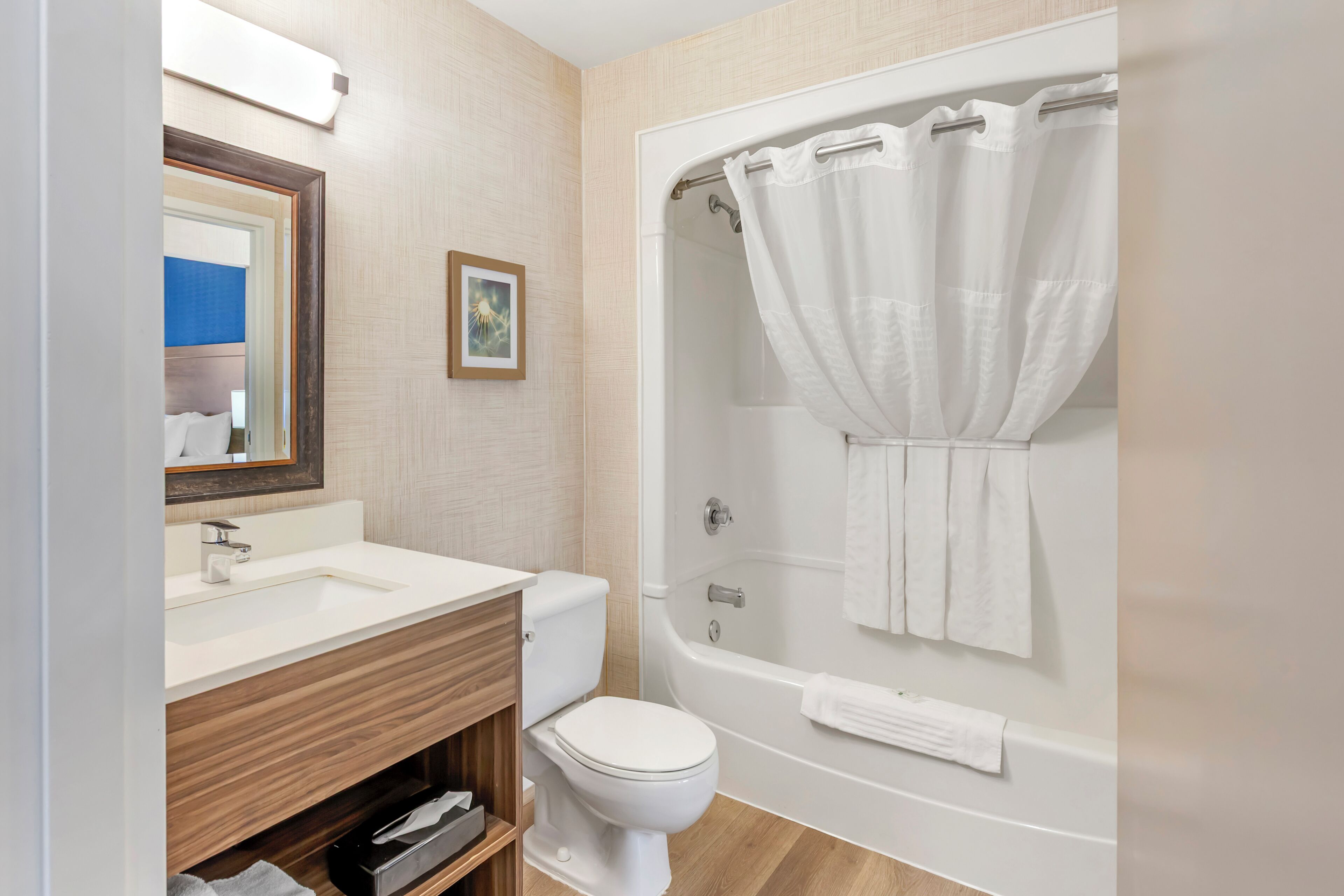 Une salle de bain avec un lavabo, des toilettes et une baignoire, le tout de couleur blanche.