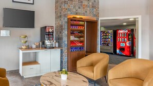 A hotel lobby with a coffee station, vending machines, and seating area. - Quality Suites Whitby (Whitby)