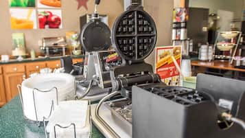 Una plancha para gofres, una pila de servilletas blancas y un panel con la carta en un restaurante.